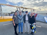 veterans standing in front of vintage biplane