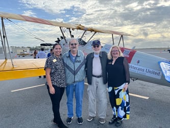 veterans standing in front of vintage biplane